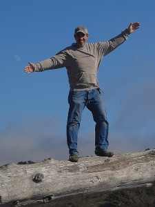 A man standing on top of a mountain with his arms outstretched.