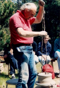 A man in red shirt swinging on a swing.