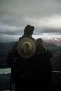 A man and woman are looking out at the mountains.