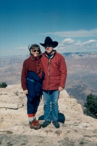 A man and woman standing on top of a mountain.