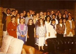 A group of people standing in front of a wall.