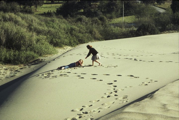 A man and woman playing in the sand.