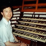 A man sitting in front of an organ.