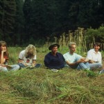 A group of people sitting in the grass.