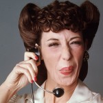 A woman with brown hair and bangs talking on the phone.