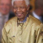 A man with white hair and wearing a gold shirt.