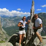 A man and woman posing for the camera on top of a mountain.